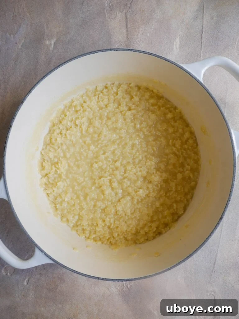 A large pot filled with creamy, cooked pastina, ready to be served.