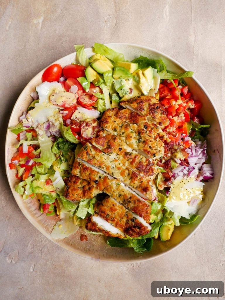 Crispy Crumbed Chicken salad in a large bowl with dressing all over