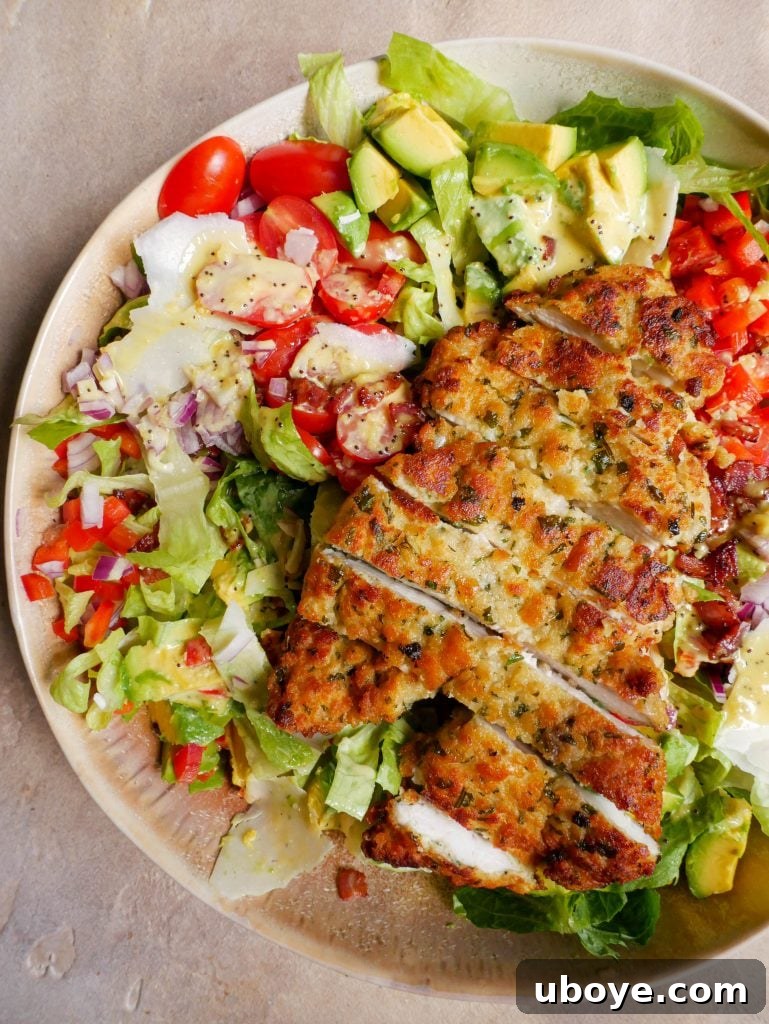 Crispy Crumbed Chicken salad in a large bowl with dressing all over