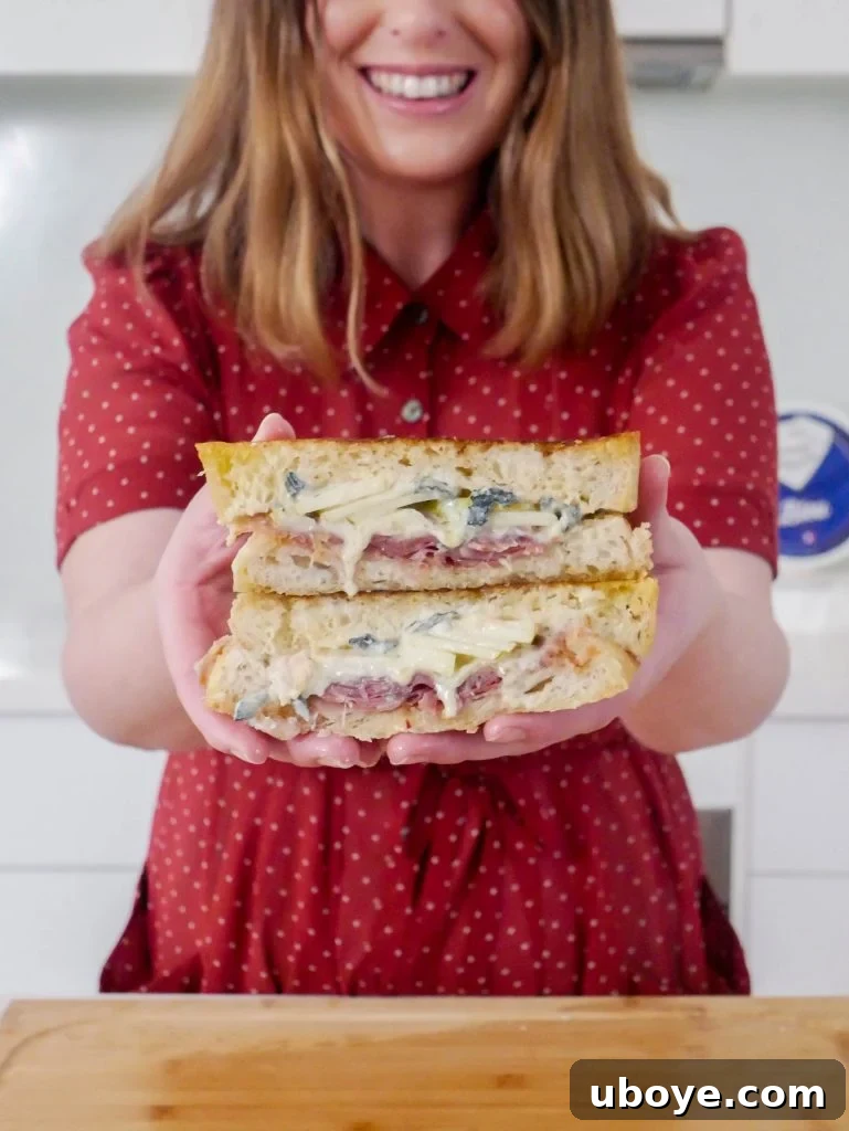 Triple Cream Brie and Hot Honey Toastie being sliced, showing the gooey cheese and layers