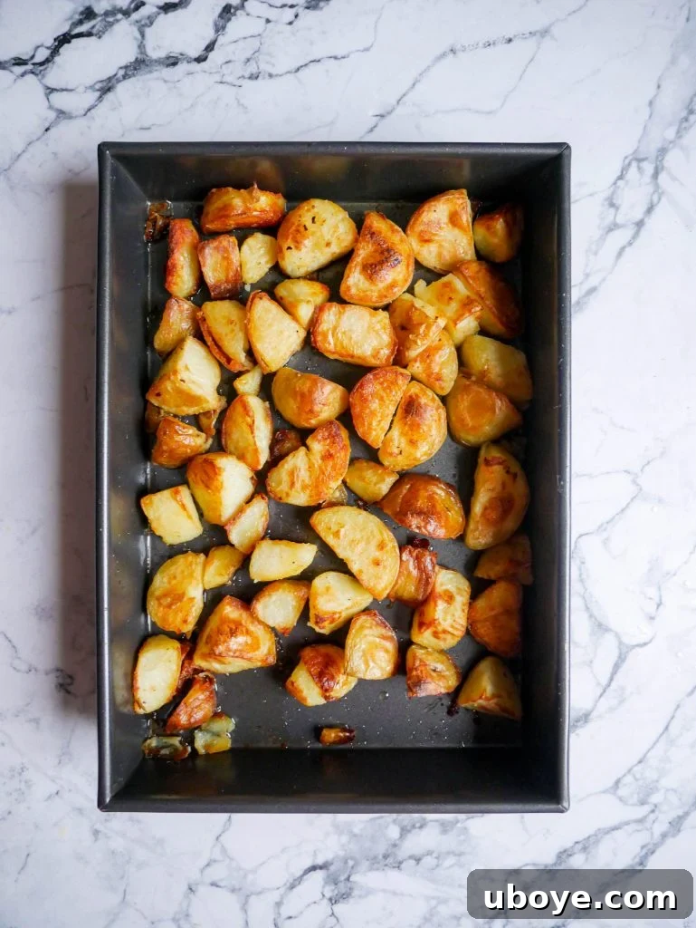 Serving of garlic confit crispy roasted potatoes in a rustic bowl, garnished with herbs
