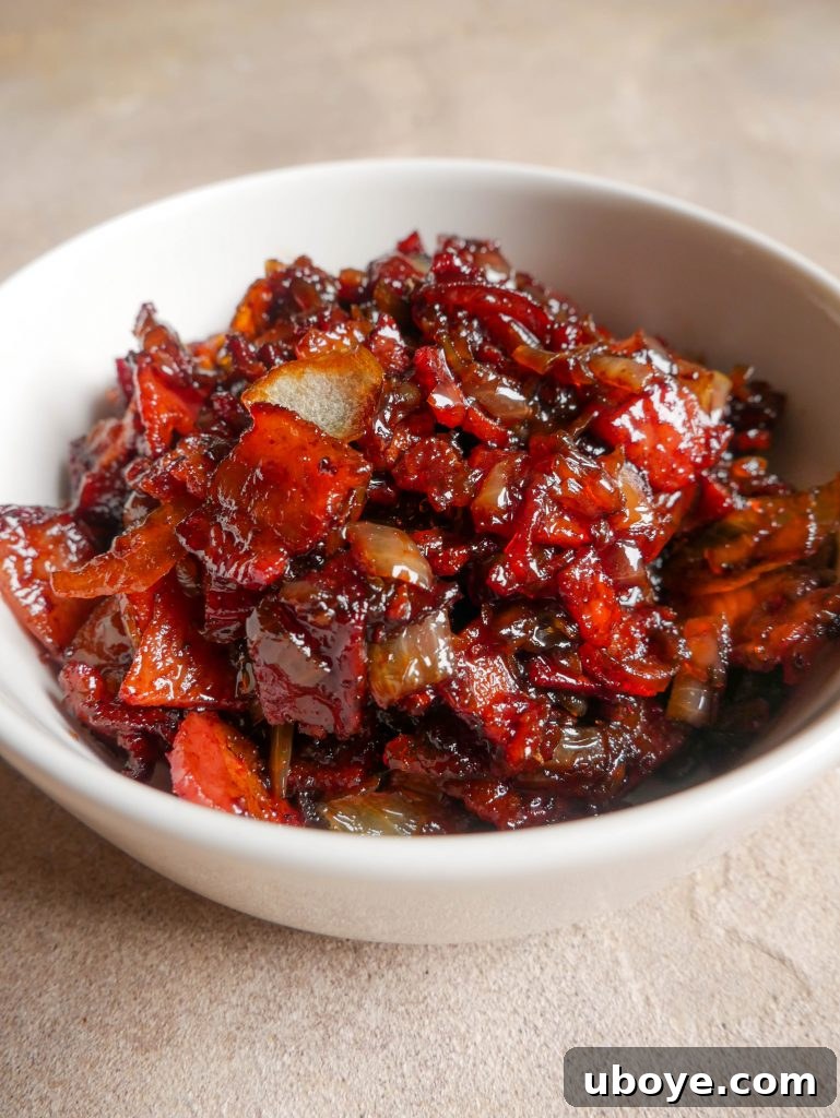 A small bowl filled with rich, dark bacon jam, garnished slightly