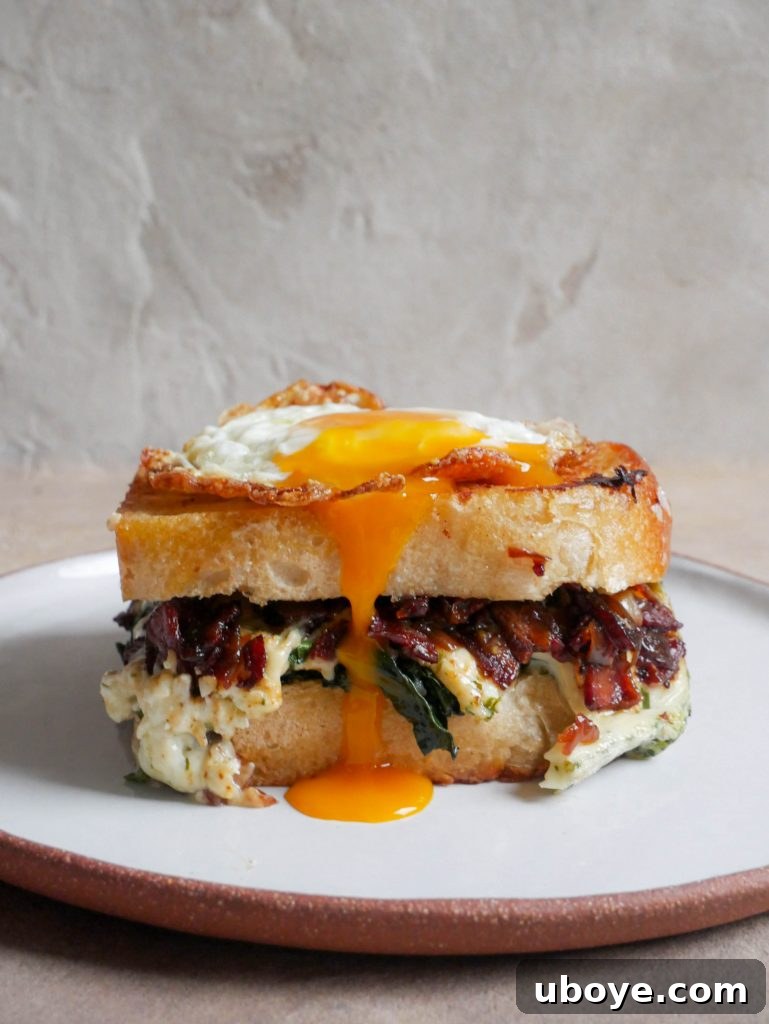 Another perspective of the breakfast toastie with a fried egg, showing the cross-section of layers