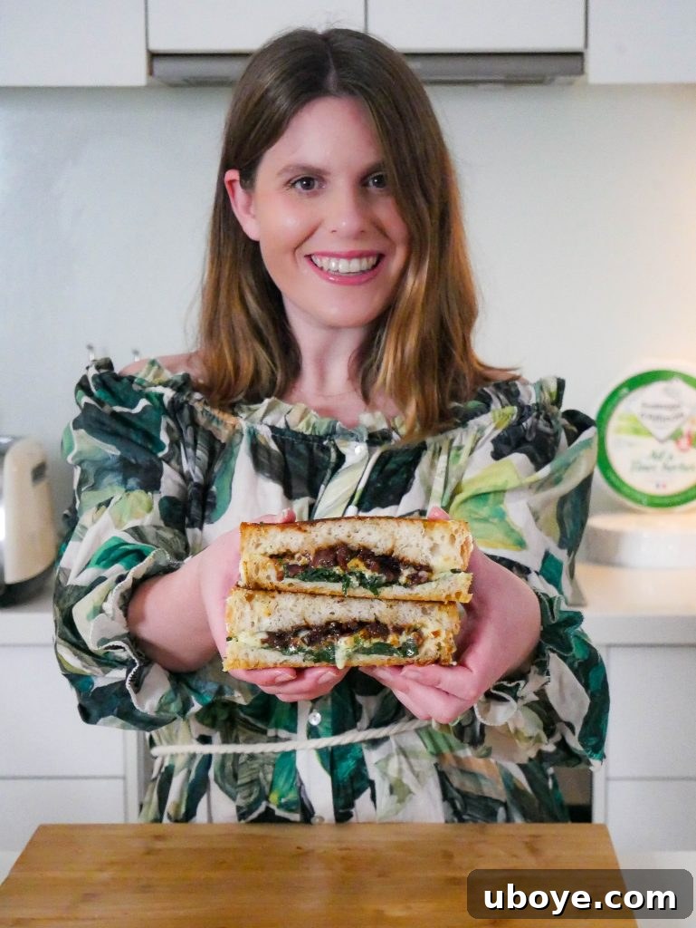 A person holding up a perfectly cooked breakfast toastie, showing off the golden brown exterior