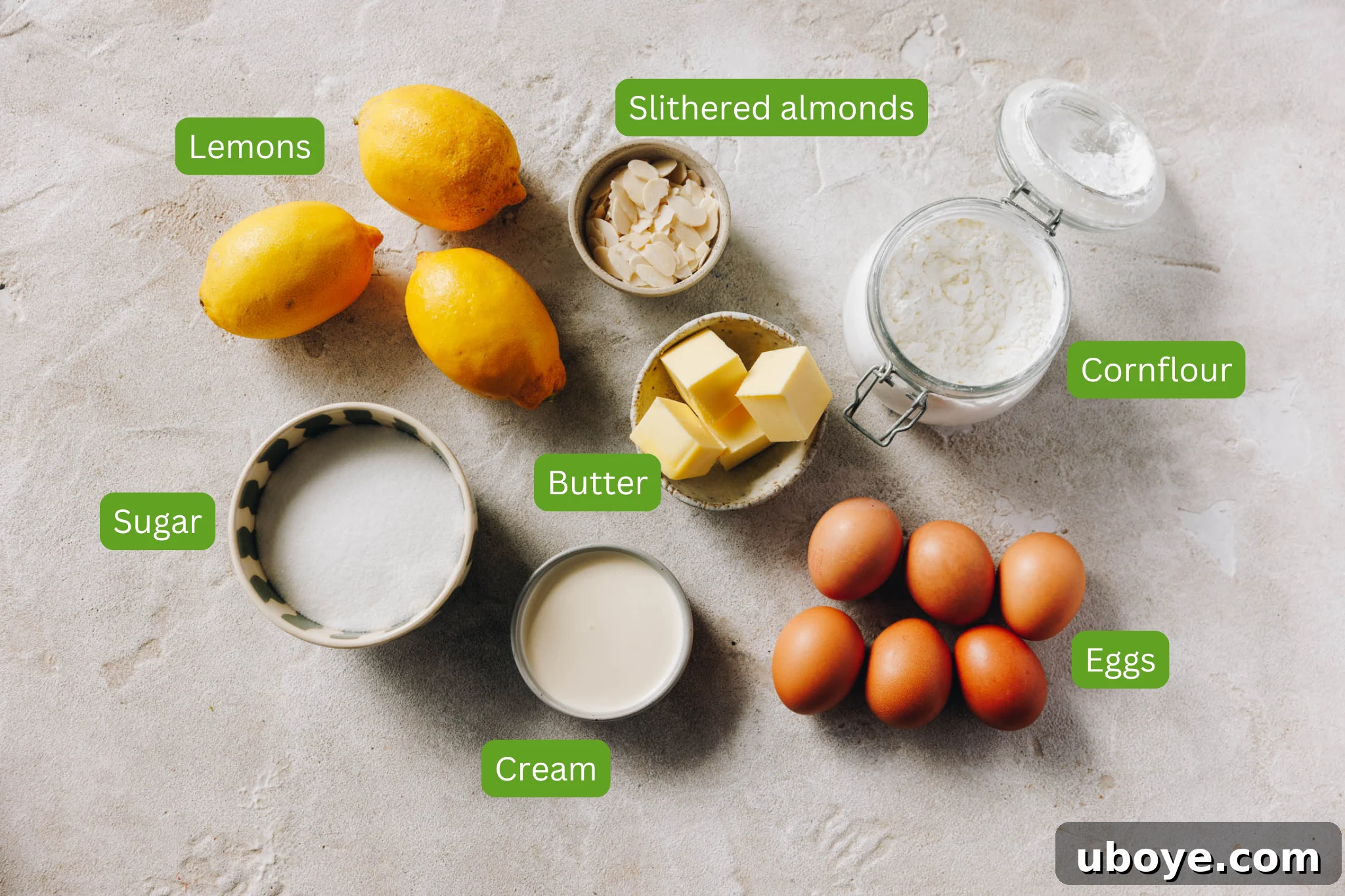 Image of ingredients needed for lemon curd meringue roulade. These include butter, cream, sugar, eggs, cornflour, almonds and lemons. 