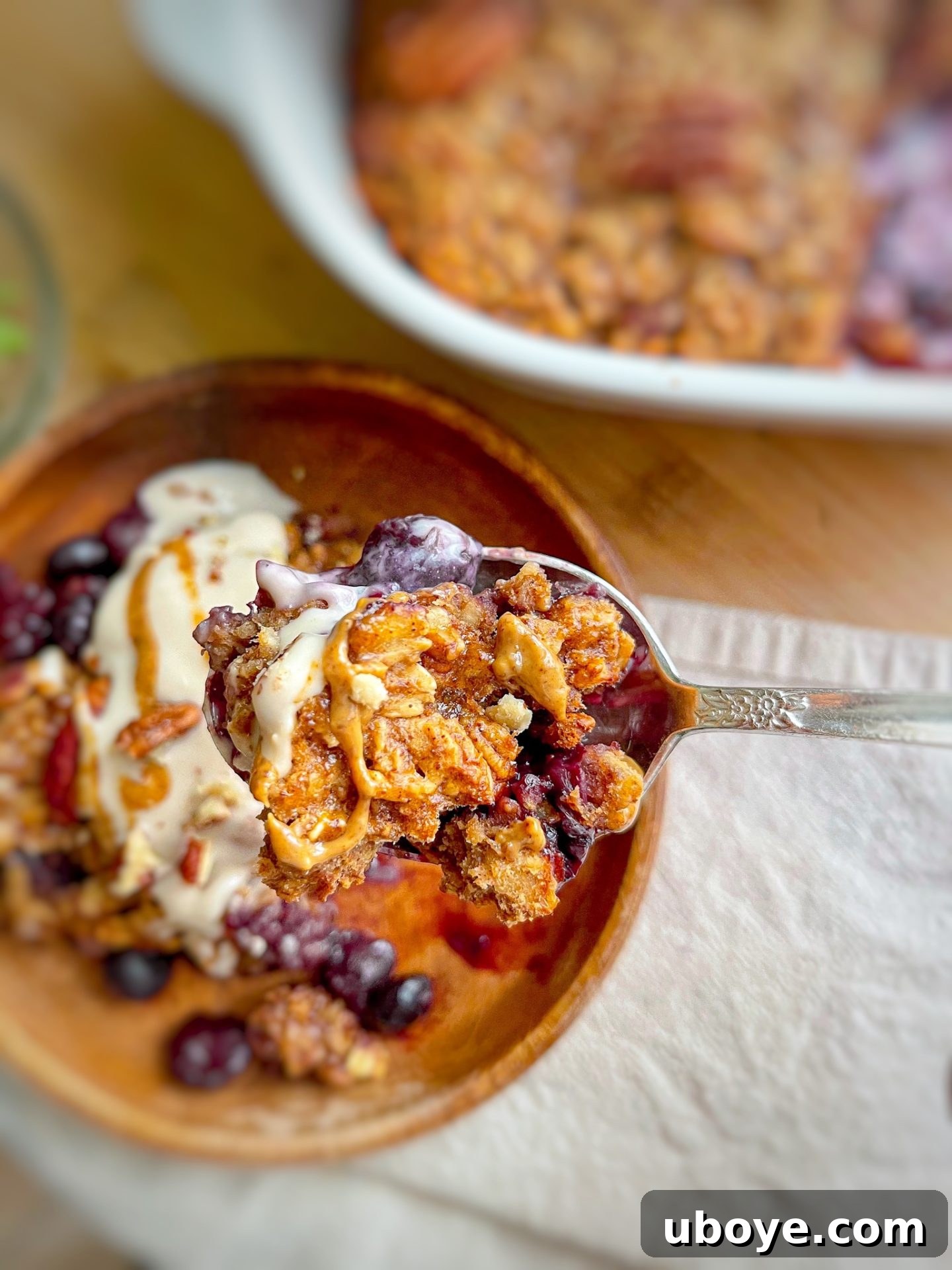 A close-up of a serving of blueberry crumble, showcasing the vibrant blueberries and golden oat topping.