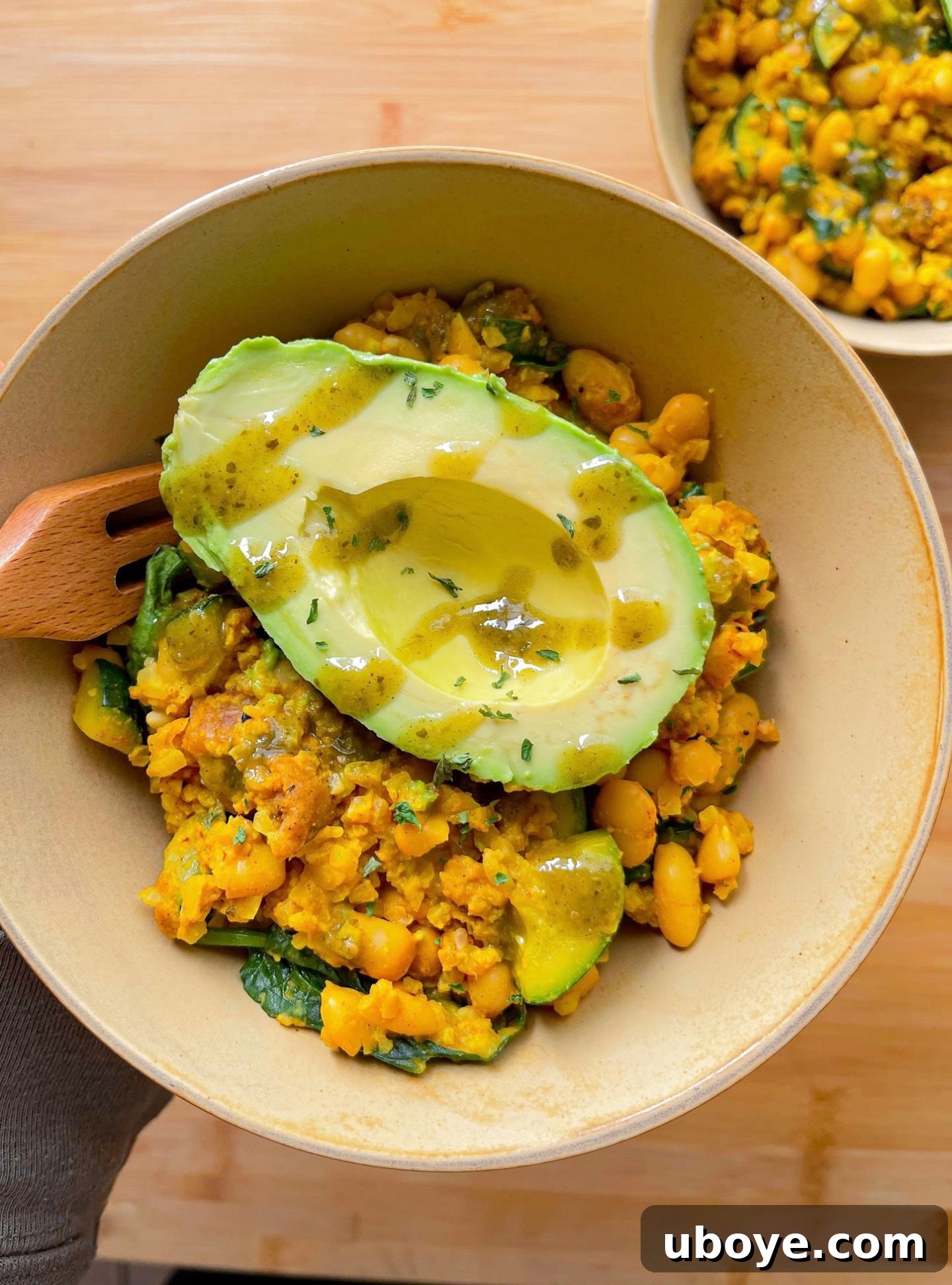 Close-up of the Savory White Bean and Veggie Scramble, generously topped with avocado