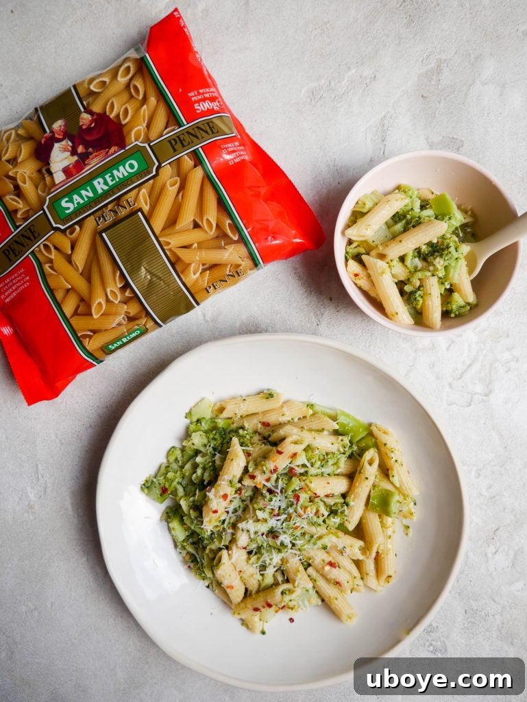 A bowl of freshly prepared cheesy broccoli pasta on a rustic wooden table, ready to be served.