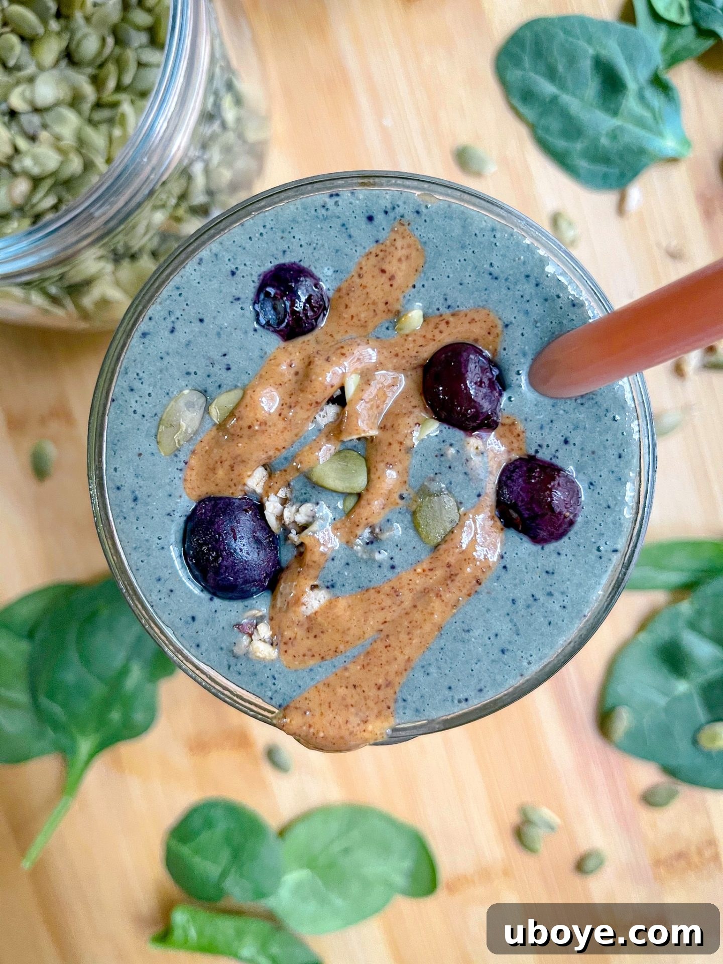 A vibrant glass of 3-Minute Blueberry Milkshake Smoothie, garnished with fresh blueberries and a straw.