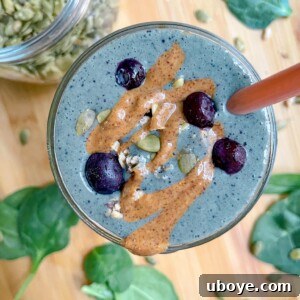 The 3-Minute Blueberry Milkshake Smoothie in a glass with a spoon, ready to be enjoyed.