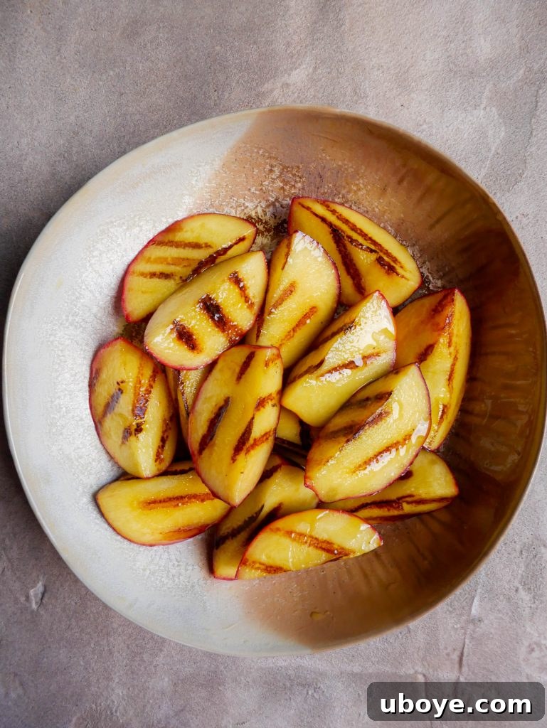 Blushing Peach Salad, Garlic Confit Infused 4 Perfectly scorched peach halves, ready for the salad, showing their caramelized edges.