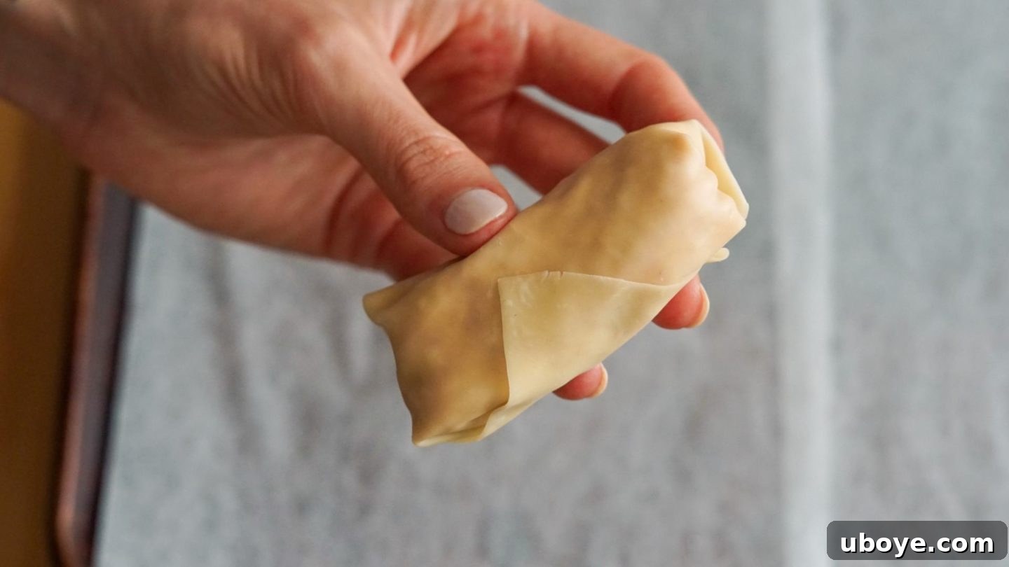 Brushing vegan eggrolls with olive oil before baking