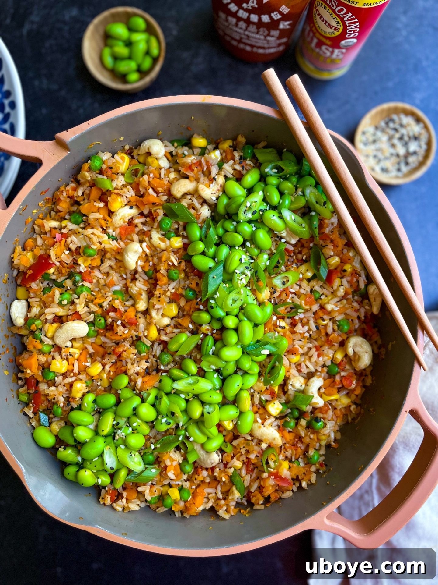 Close-up of a pan of homemade vegetable fried rice, showing the mixture of frozen and fresh ingredients being stir-fried.