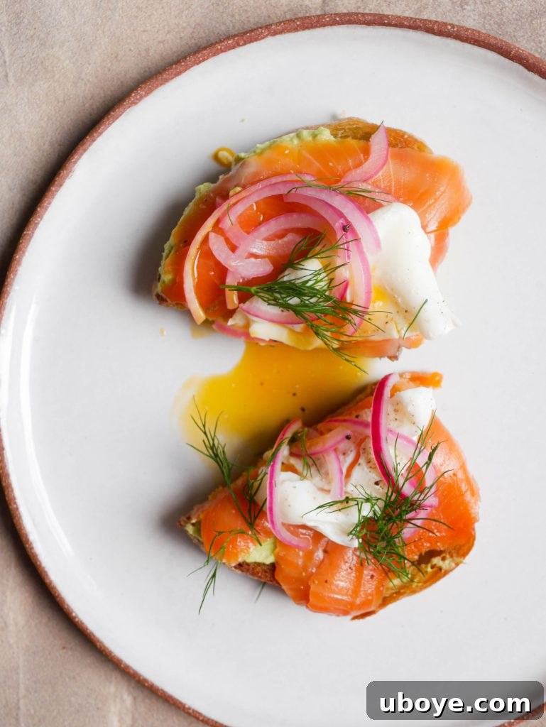 Delicious Avocado smash with quick pickled onions and a poached egg on sourdough toast, garnished with fresh dill.