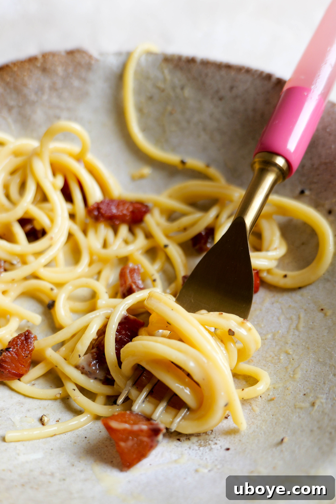 Authentic Roman Carbonara 3 Close-up of golden guanciale cubes frying in a pan, releasing their rich fat.