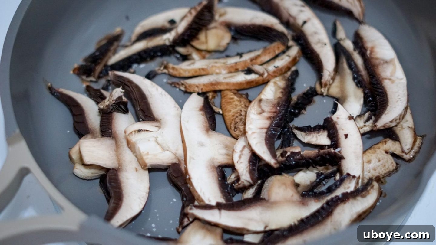 Close-up showing how to brown mushrooms evenly in a dry pan