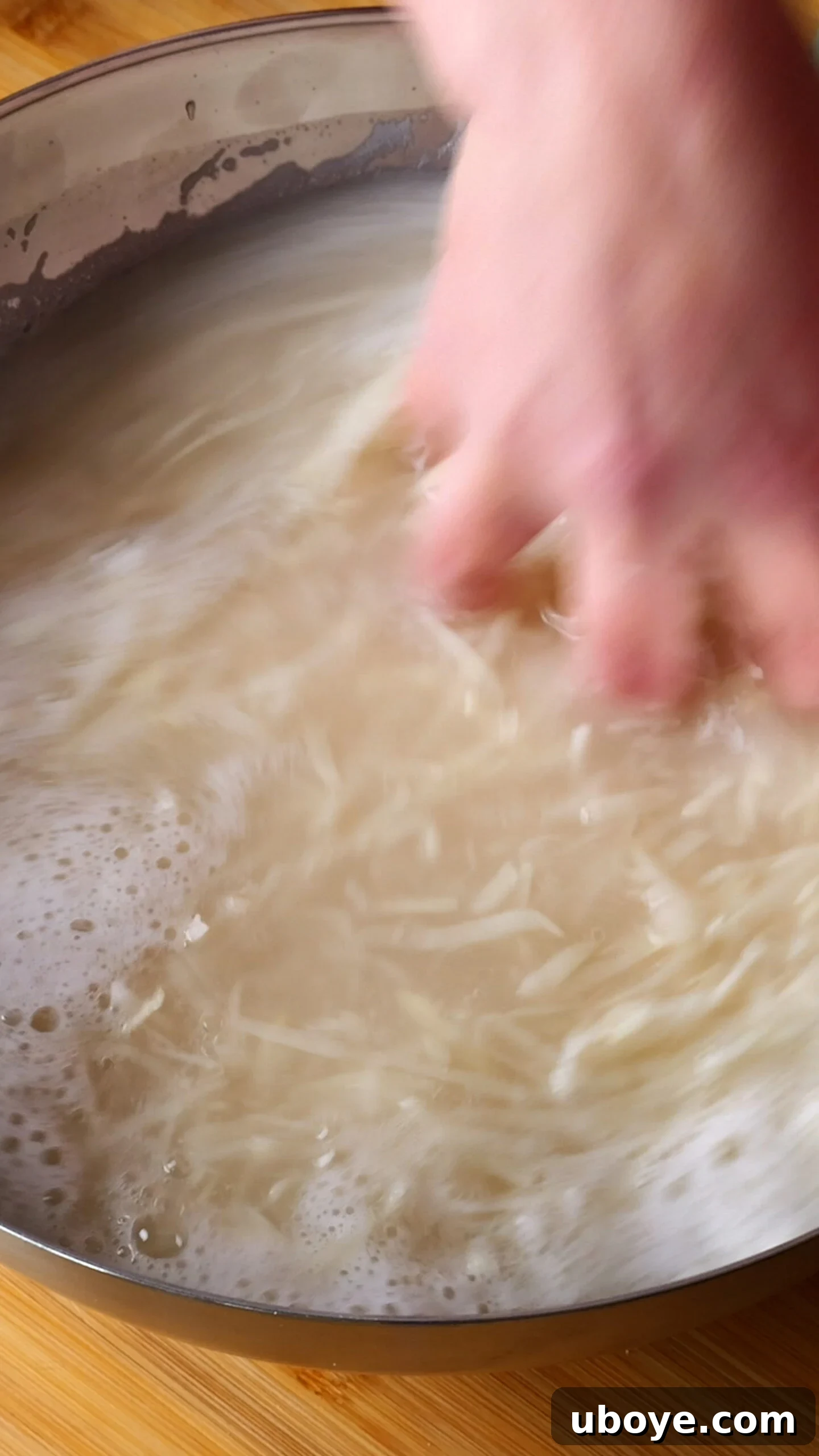 Golden Crispy Potato Rosti 5 Grated potatoes submerged in a bowl of cold water, beginning to release starch.