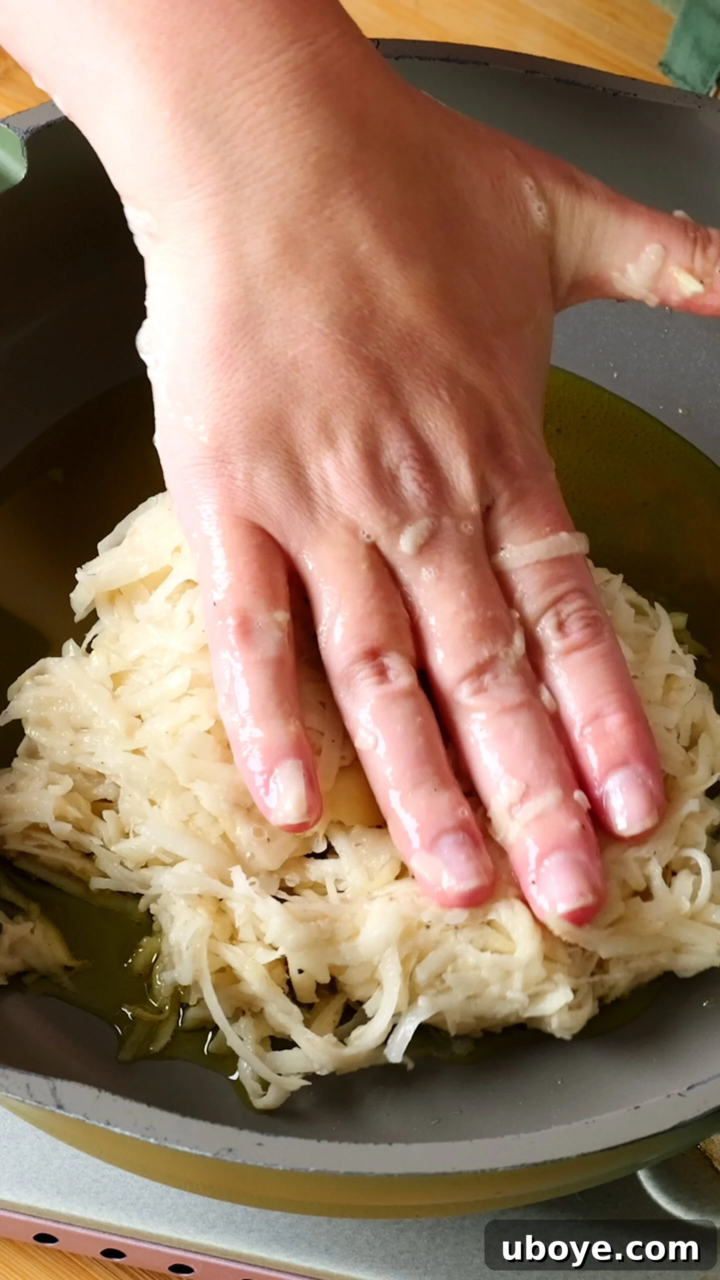 Golden Crispy Potato Rosti 9 Grated potato mixture being carefully pressed into a hot pan with olive oil, ready for frying.