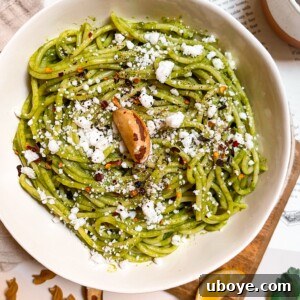 Close-up of freshly made vegan Brazil nut pesto in a small ceramic bowl, with a spoon.