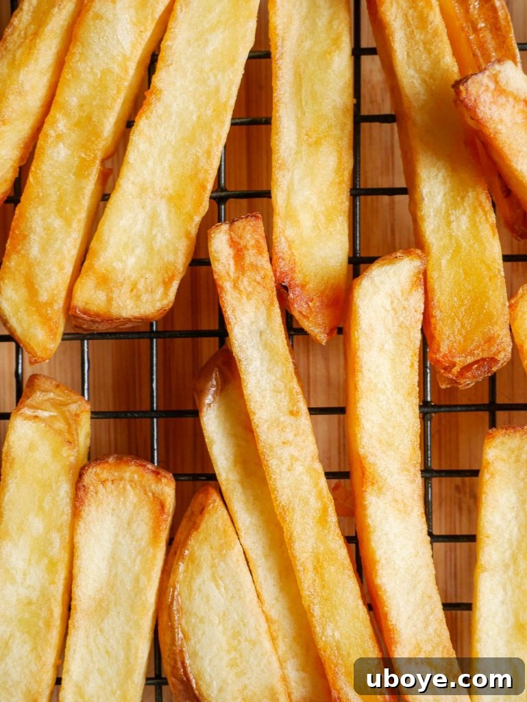 A large serving of hot, crispy triple-cooked chips piled high, perfectly seasoned.