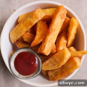 A serving of crispy triple-cooked chips, ready to be seasoned and enjoyed.