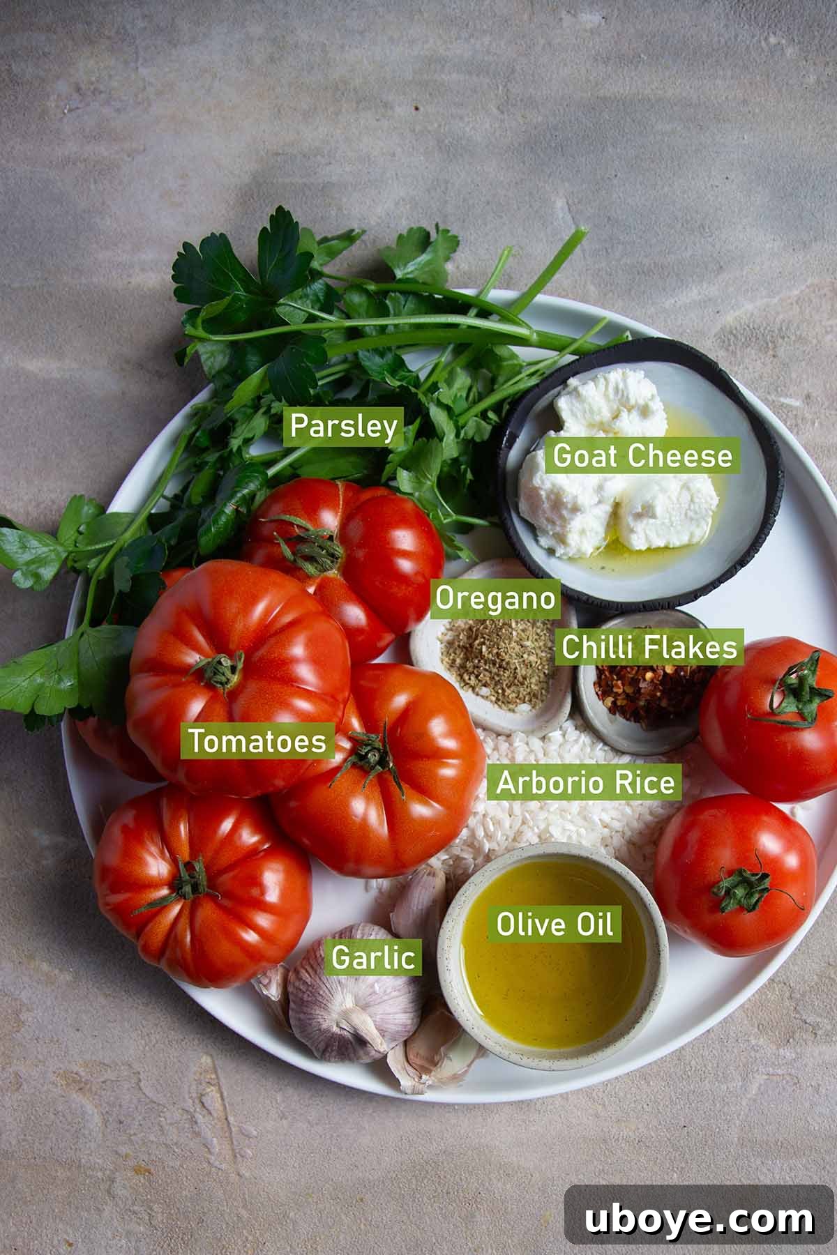 Mediterranean Tomato Treasures 3 Fresh ingredients for stuffed tomatoes laid out on a large platter, including ripe beefsteak tomatoes, fresh herbs, goat cheese, and Arborio rice.