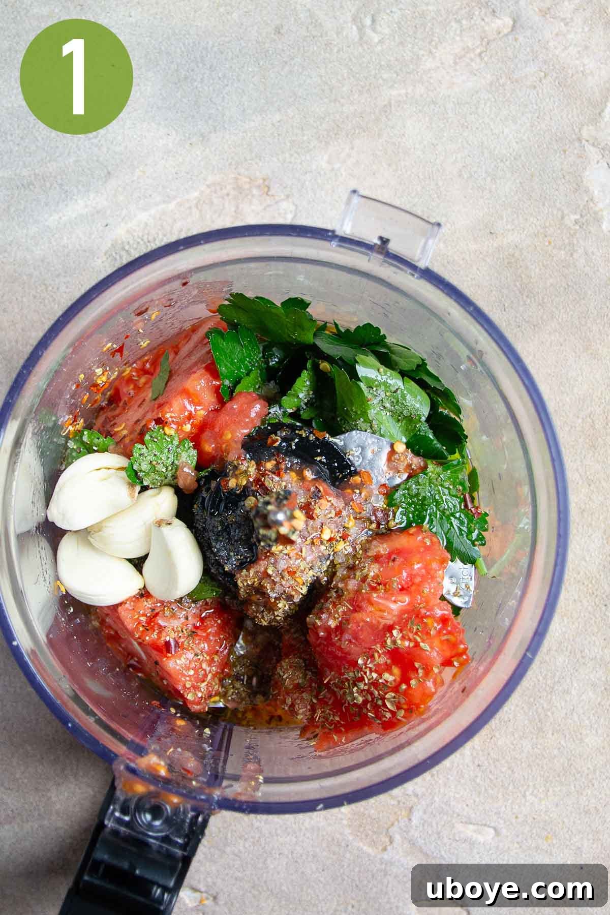 Mediterranean Tomato Treasures 4 Scooped tomato flesh, fresh garlic, and green herbs in a food processor, ready to be blended into the stuffing base.