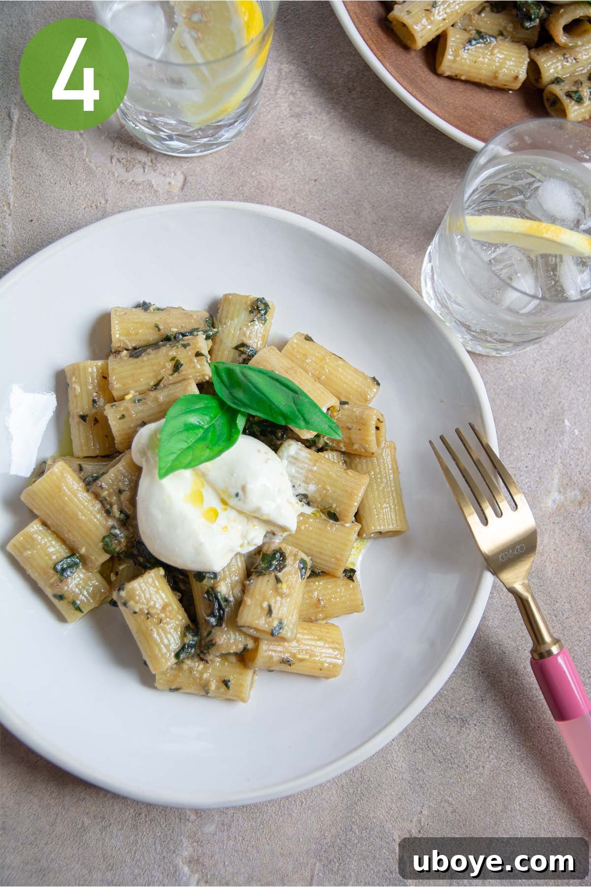 Velvet Garlic Pesto Pasta 7 A serving of garlic confit pesto pasta topped with a generous portion of creamy burrata cheese and fresh basil.
