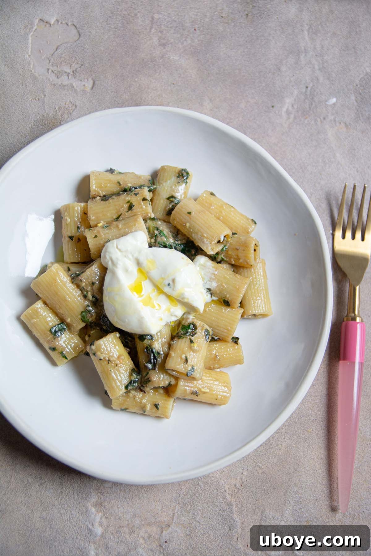Velvet Garlic Pesto Pasta 8 A fork piercing through a succulent bite of garlic confit pesto pasta, showcasing its rich texture and vibrant color.