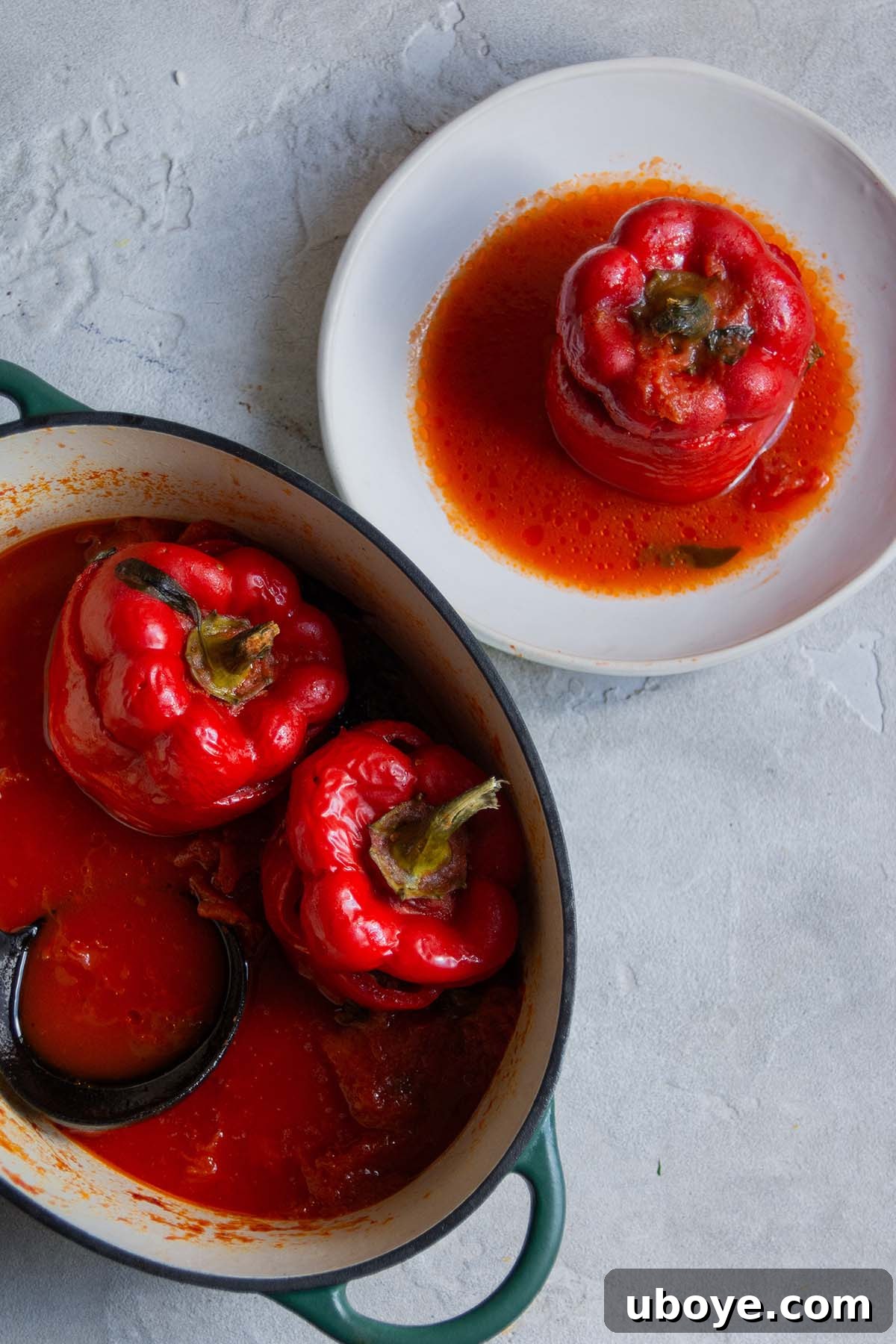Hearty Beef and Rice Stuffed Peppers 2 Stuffed red bell peppers cooking in a pot and served on a plate, showcasing their inviting appearance.
