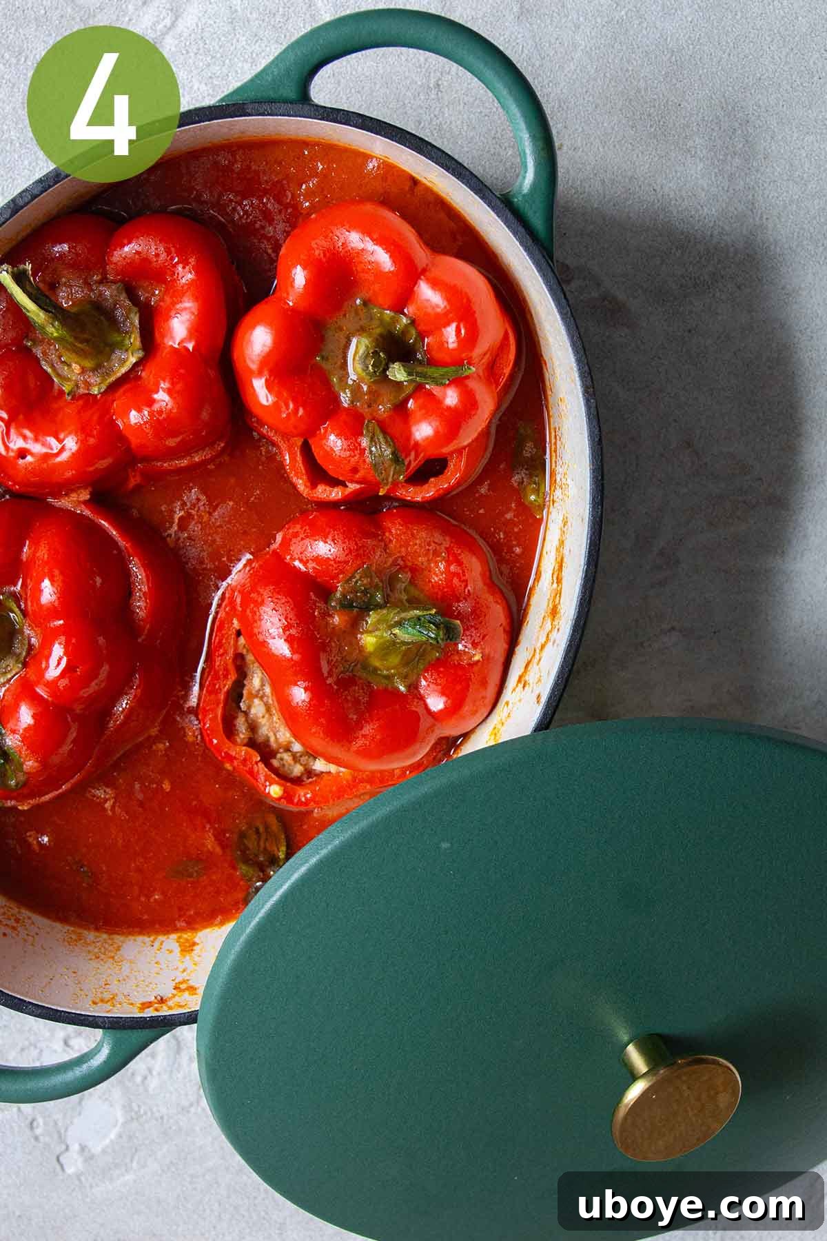 Hearty Beef and Rice Stuffed Peppers 7 Four stuffed bell peppers simmering in a small pot, covered.