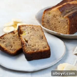 Two slices of indulgent olive oil banana bread with banana garnish, indicating its delightful flavor and moist texture.