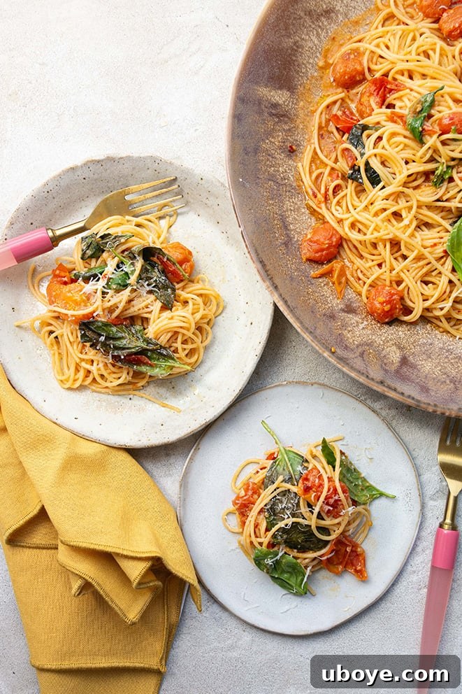 Garden Fresh Cherry Tomato Basil Pasta 8 A beautifully presented cherry tomato and basil pasta dish in a large marbled bowl, with two smaller individual servings ready to be enjoyed. Fresh basil leaves are scattered over the top for garnish.