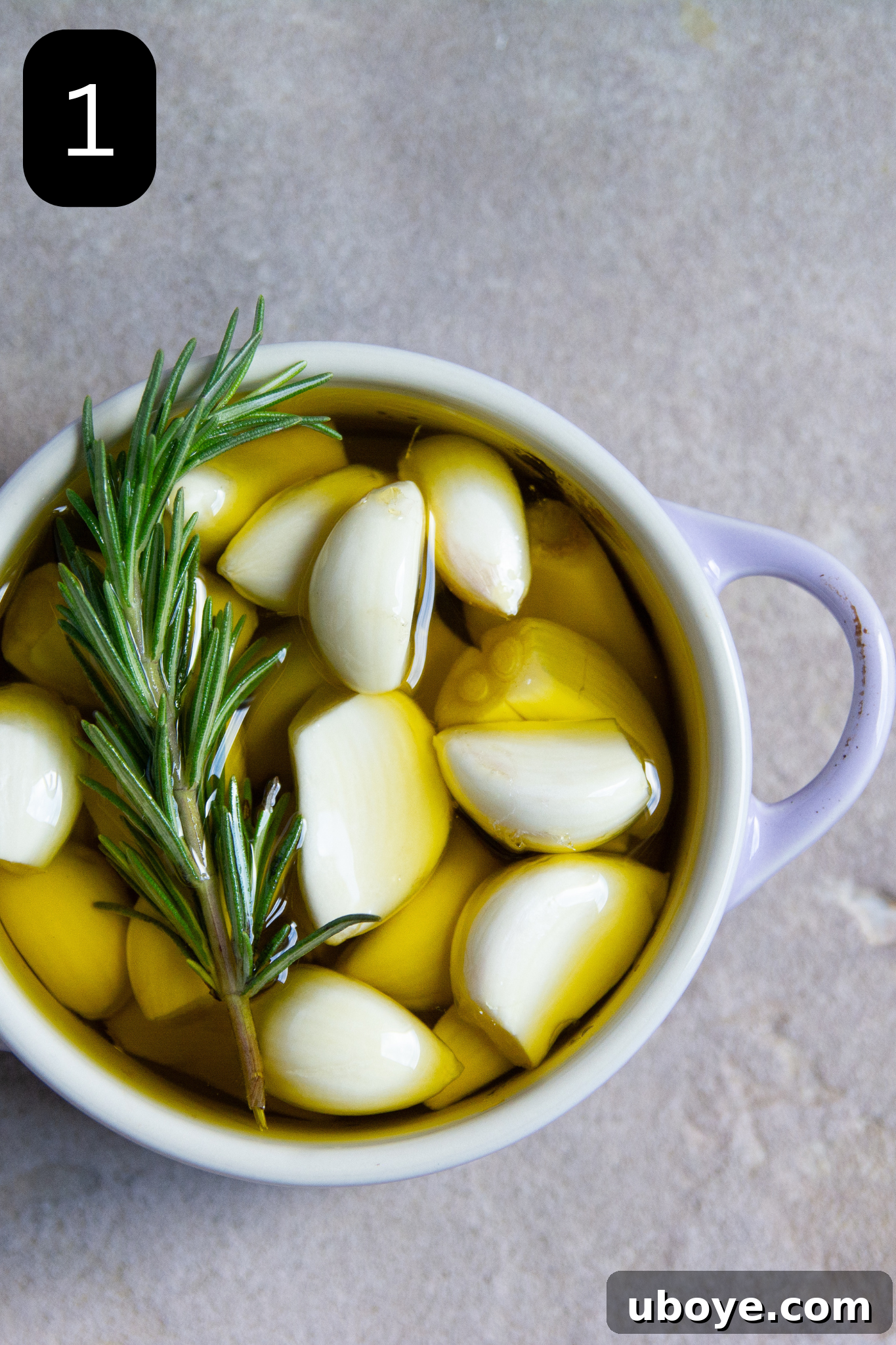 Fiery Feta and Red Pepper Dip 4 Fresh garlic cloves submerged in olive oil with a rosemary sprig in a small ovenproof dish.