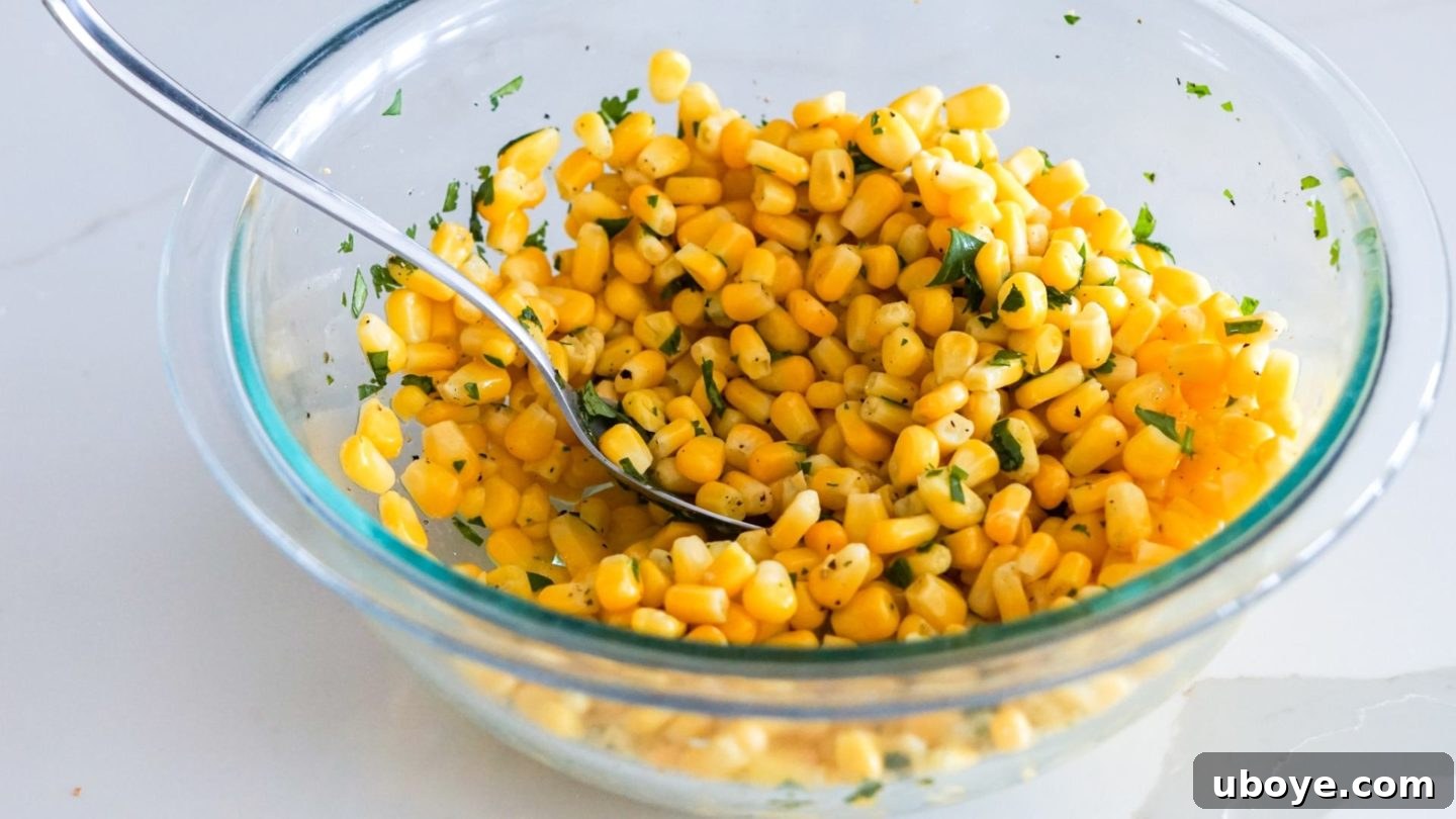 Epic Vegan 7 Layer Dip 8 Yellow corn kernels mixed with fresh lime juice, chopped cilantro, and salt in a bowl, ready for layering.