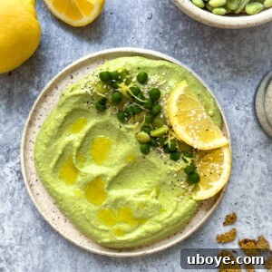 Vibrant green lima bean hummus served on a white plate, ready to be enjoyed.