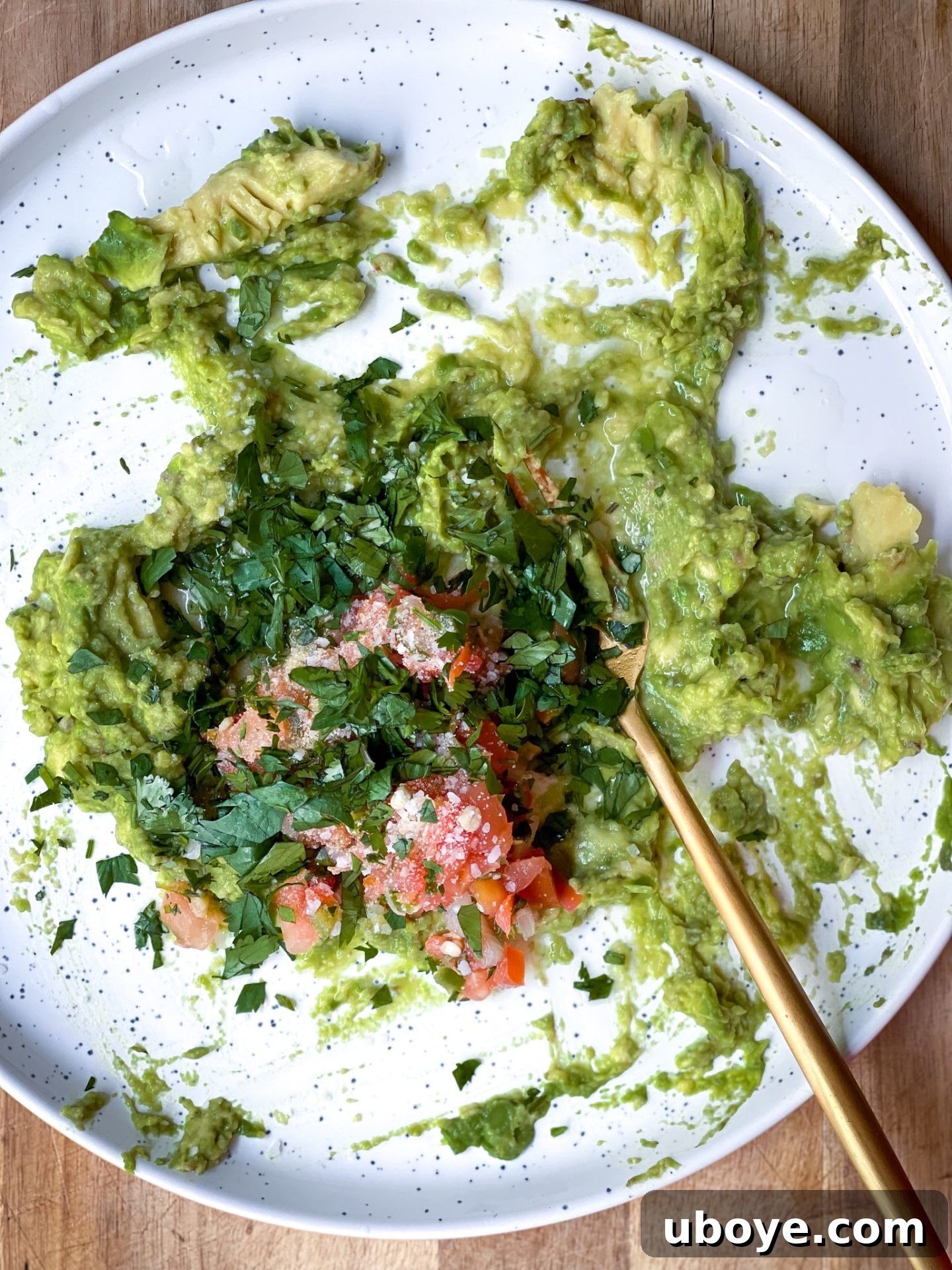 One Avocado Wonder 4 Essential guacamole ingredients arranged on a simple white plate, featuring an avocado, lime, garlic powder, and pico de gallo.