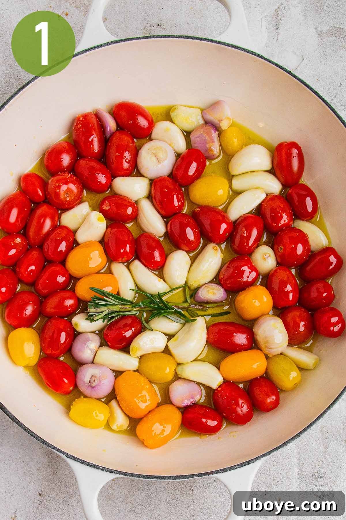 Golden Garlic Tomato Pasta 4 Cherry tomatoes, peeled garlic cloves, shallots, and a sprig of fresh rosemary being combined in a cast iron baking dish with olive oil and salt.