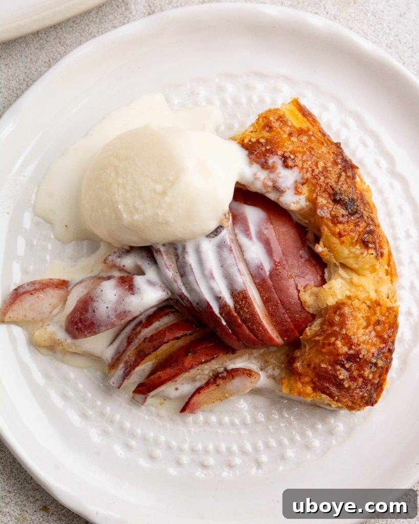 Baked apple cinnamon galette with cheesy pastry, garnished with a scoop of ice cream