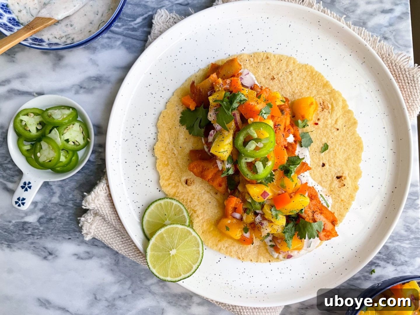 Delicious vegan chick'n tacos with mango salsa and cilantro yogurt sauce on a white plate