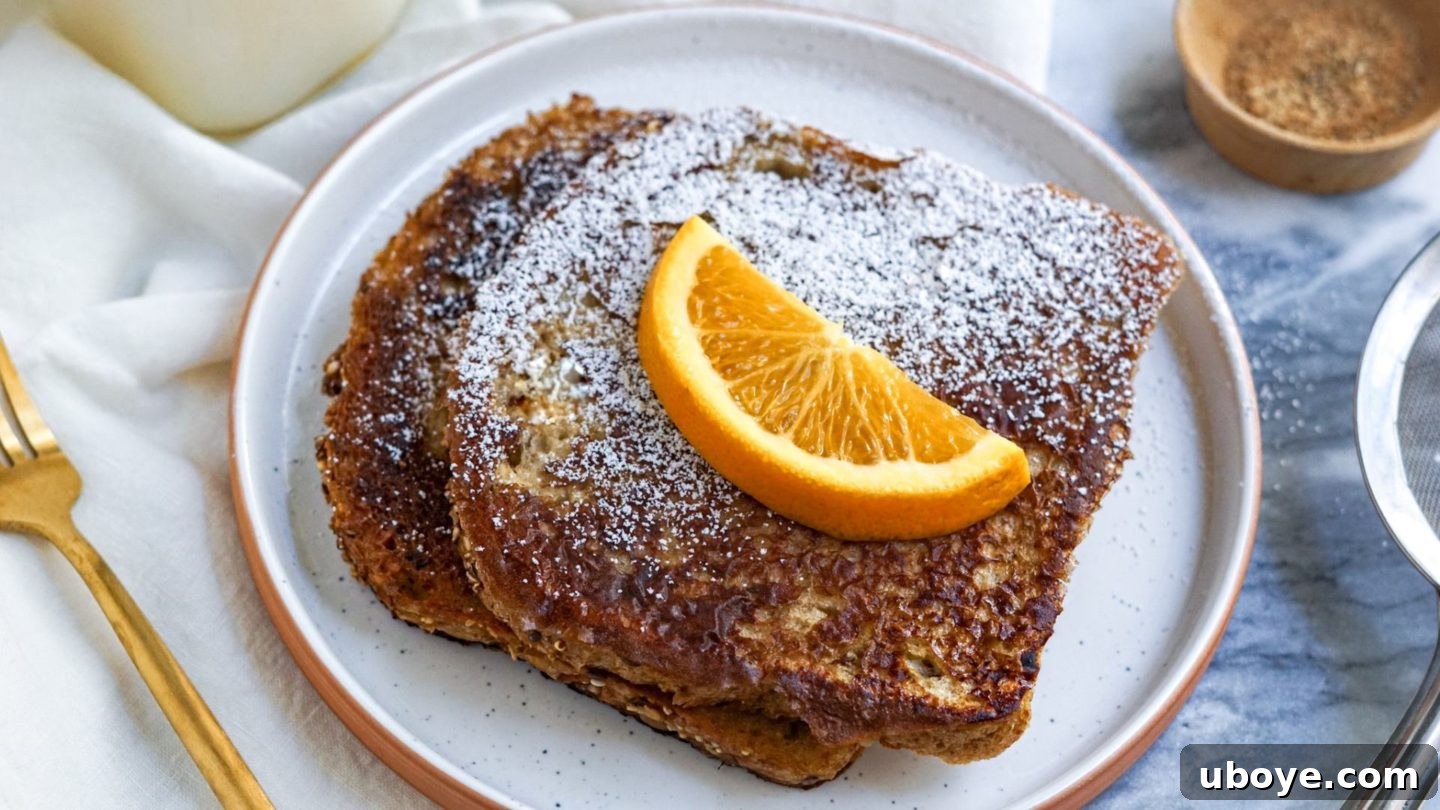 A stack of golden-brown vegan French toast slices beautifully arranged on a white plate, garnished with vibrant fresh orange segments and a light dusting of powdered sugar, presenting an inviting breakfast.