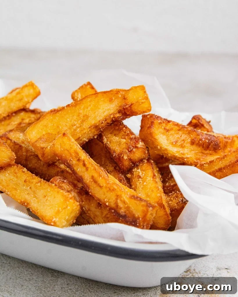 Savory Chicken Salt Chips 4 An organized arrangement of freshly peeled and uniformly cut Russet potatoes, ready for the crucial triple-cook preparation process.