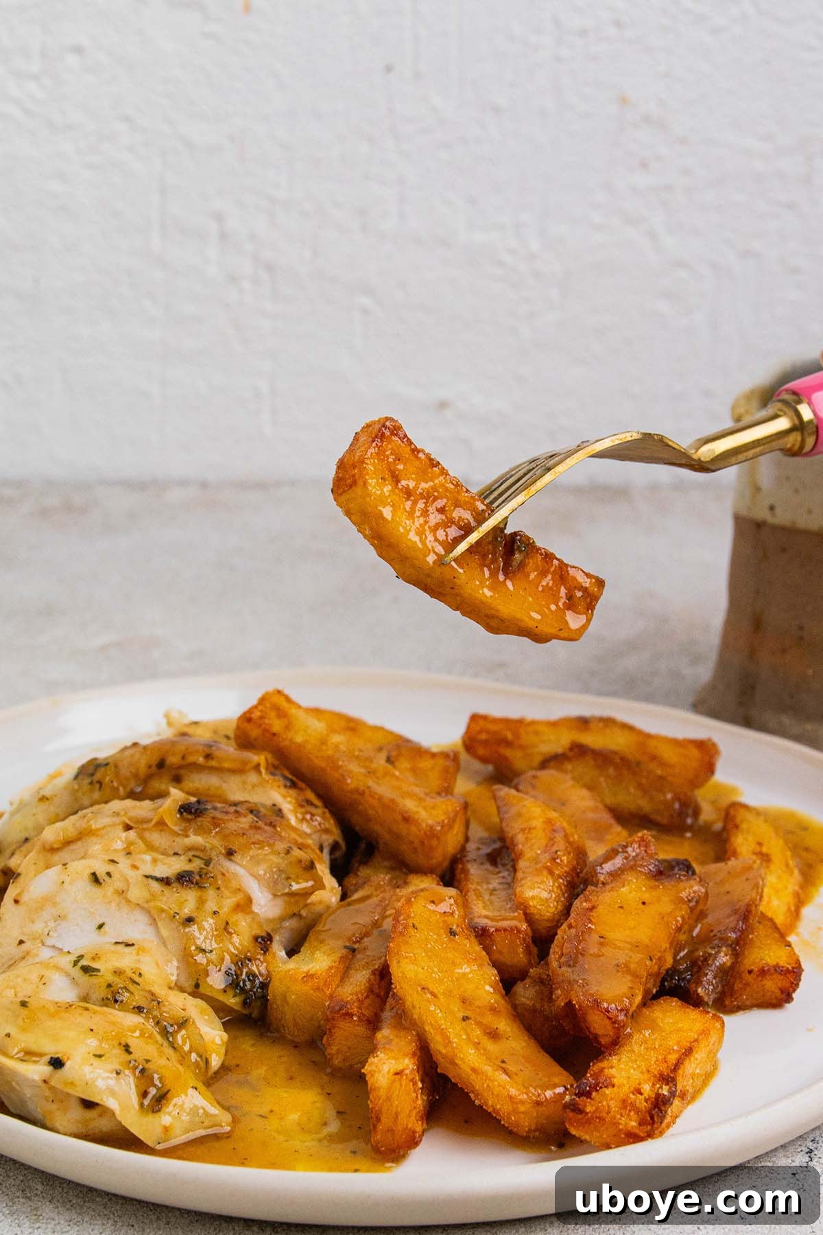 A forkful of crispy chips generously covered in thick, rich chicken gravy.