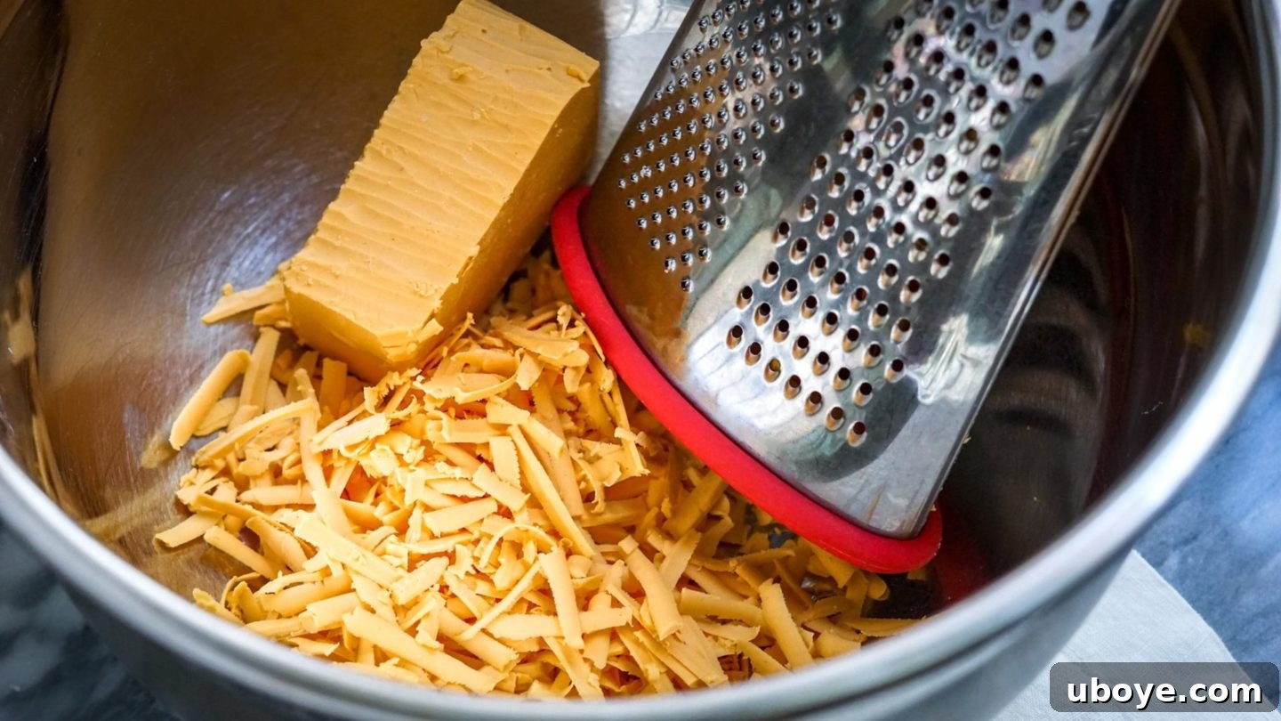 Bowl of freshly grated vegan cheddar cheese, perfect for achieving a superior melt in a breakfast casserole.