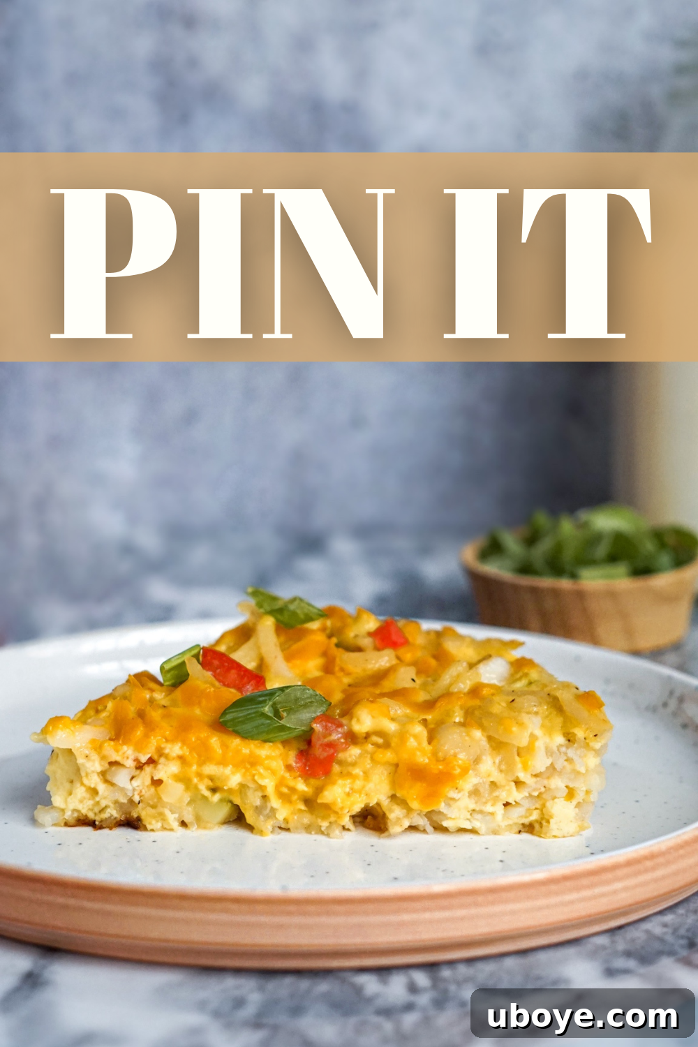 Close-up of a perfectly cooked vegan egg and cheese hash brown skillet, garnished with fresh green onions, ready to be served.