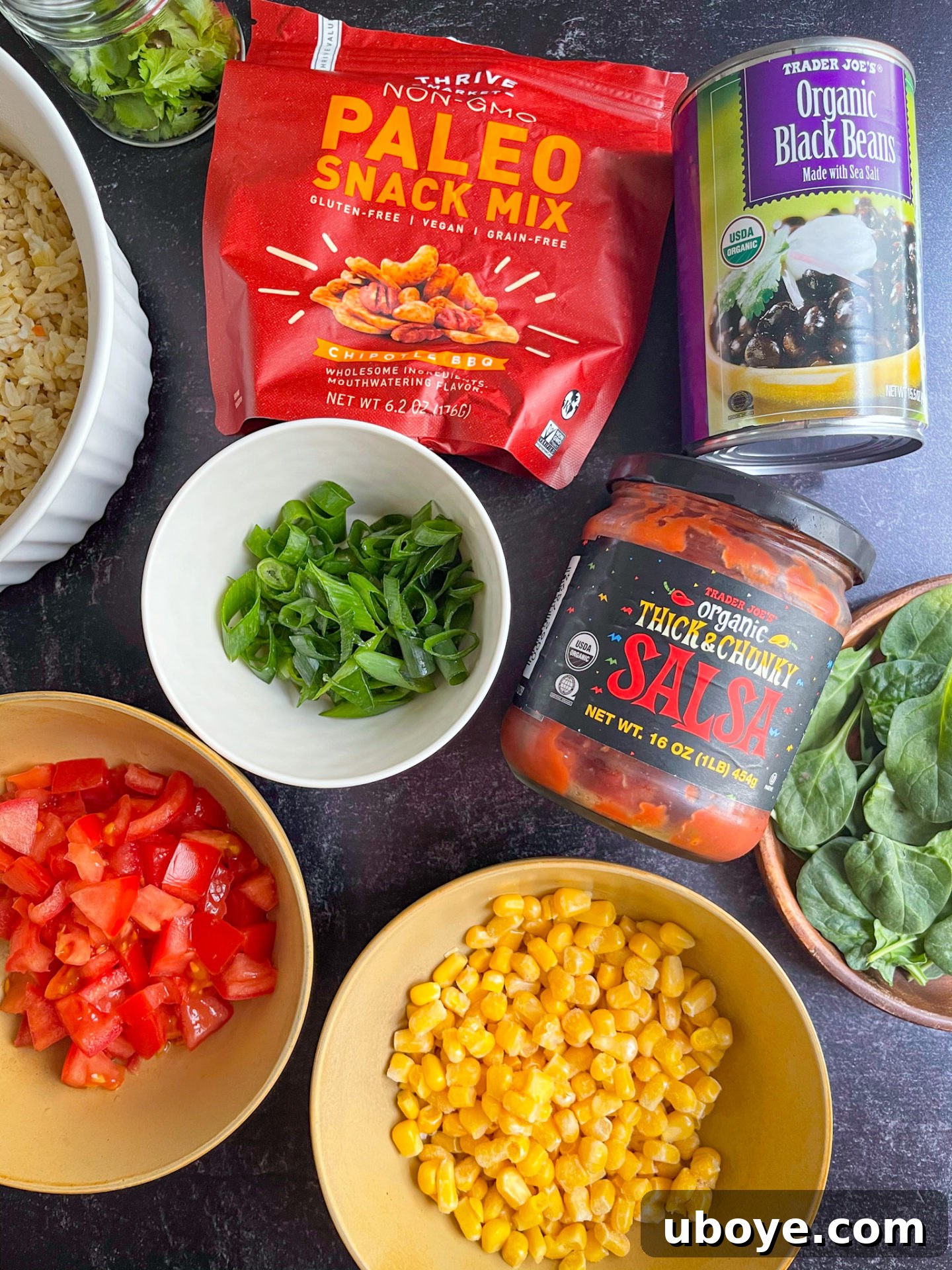 Fresh & Simple Summer Meal Prep 2 A selection of fresh ingredients including vegetables, herbs, and beans arranged on a dark countertop, symbolizing preparation for healthy summer meal prep.