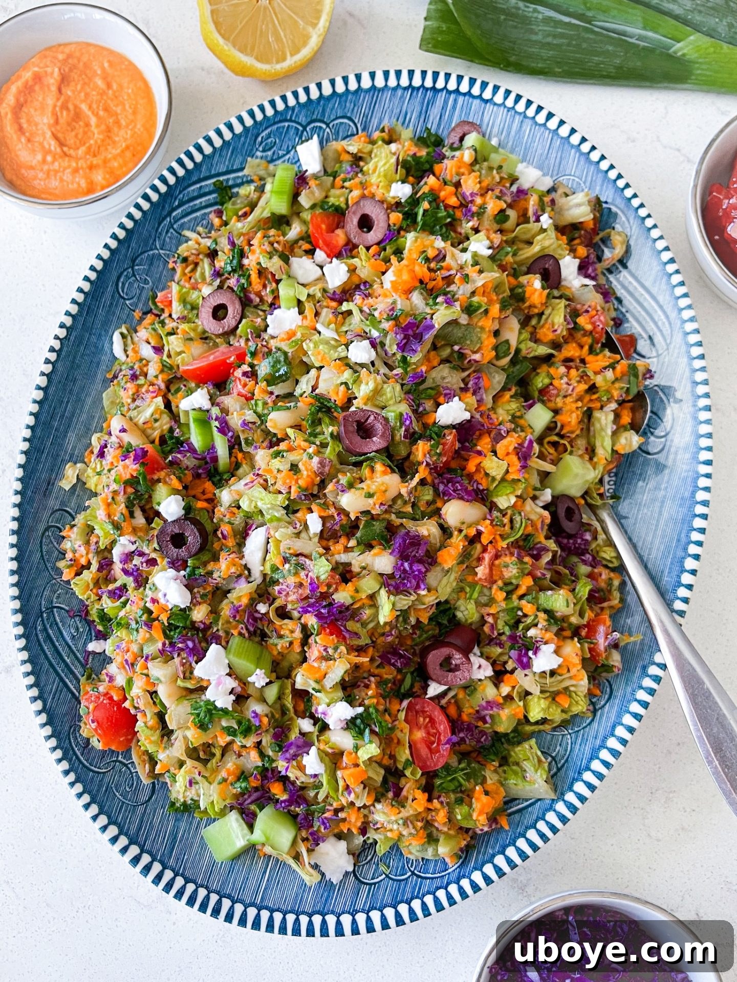 Fresh & Simple Summer Meal Prep 3 A vibrant vegan chopped salad with creamy white bean dressing, featuring fresh greens and colorful vegetables, presented in a clear bowl.