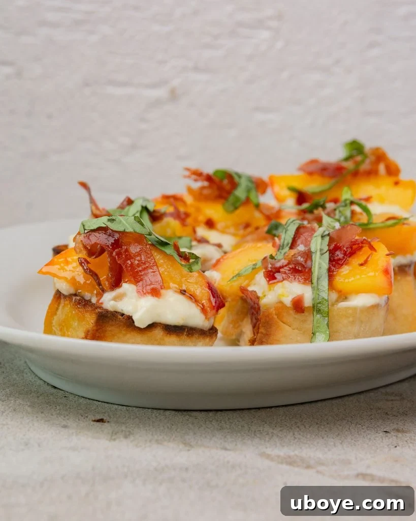 Close-up shot of grilled peaches, prosciutto, and burrata on a baguette slice