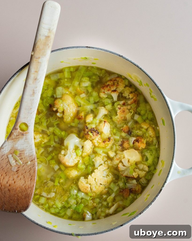 Creamy Cauliflower Delight 4 A bowl of creamy cauliflower soup garnished with fresh thyme and a drizzle of olive oil.