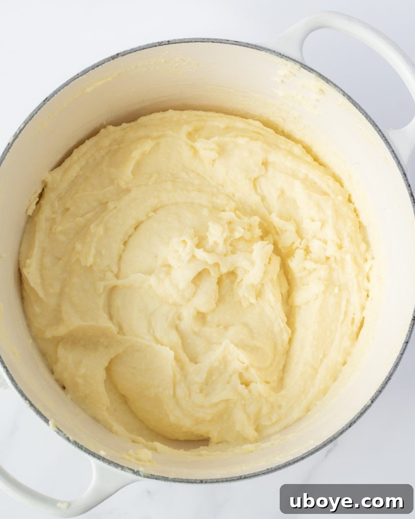 Garlic Infused Butter Mash 4 Perfectly boiled and drained potatoes steaming in a colander under a tea towel.